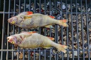 bovenaanzicht van gegrilde verse vis. koken bbq zeevruchten in brand buitenshuis. foto