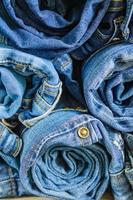 roll blue denim jeans gerangschikt in stapel, achtergrondstructuur. beauty en mode kleding concept foto