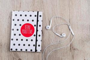 bovenaanzicht van hotebook met polka dot cover en witte koptelefoon op houten tafel. minimale platligging. foto