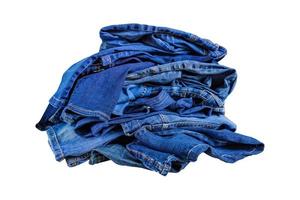 stapel blauwe denim jeans in een puinhoop geïsoleerd op witte bckground. foto