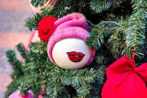 Kerstmis en Nieuwjaar vakantie achtergrond. kerstboom versierd met speelgoed met gebreide rode muts. viering concept foto