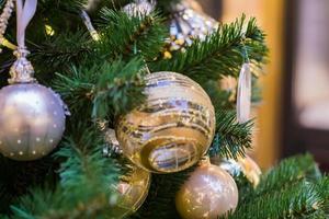 close-up van de kerstboom versierd met gouden en witte ballen en sneeuwvlok. nieuwjaar achtergrond foto