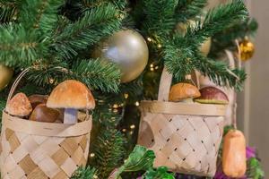 Kerstmis en Nieuwjaar vakantie achtergrond. kerstboom versierd met mand met champignons en kool. viering concept foto