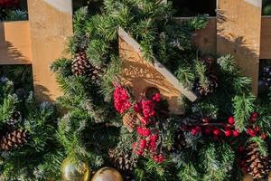 kerst buiten decoratie van hek. takken met ballen en guirlande en decoratief vogelhuisje foto