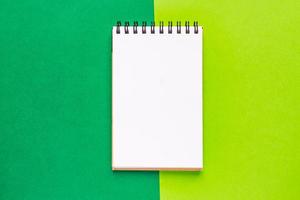 spiraal notitieboek op groene achtergrond. schoon notitieboek voor doelen en resoluties. mockup voor uw ontwerp. foto