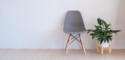 grijze stoelen en groene planten op de houten vloer in een minimale kamer. foto