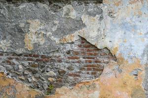 oude muur van baksteen met een strooi pleister. foto