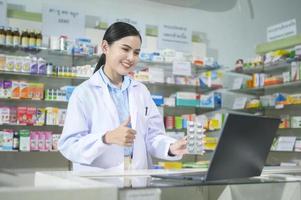 vrouwelijke apotheker die klant adviseert via videogesprek in een moderne apotheekdrogisterij. foto