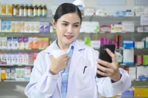 vrouwelijke apotheker die klant adviseert via videogesprek in een moderne apotheekdrogisterij. foto