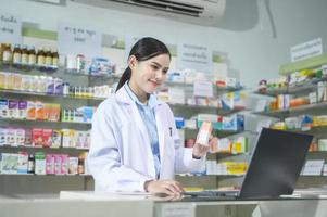 vrouwelijke apotheker die klant adviseert via videogesprek in een moderne apotheekdrogisterij. foto