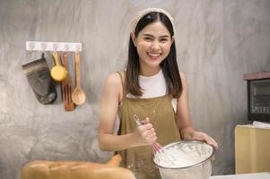 jonge mooie vrouw bakt in haar keuken, bakkerij en coffeeshopbedrijf foto