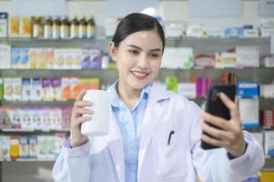 vrouwelijke apotheker die klant adviseert via videogesprek in een moderne apotheekdrogisterij. foto