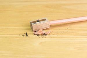 potlood en puntenslijper op houten tafel foto