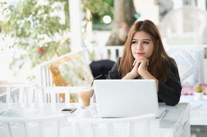 Azië jonge zaken vrouw zitten in café met laptop foto