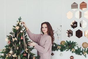 vrouw versieren Kerstmis boom foto