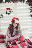 vrouw is zittend Aan de bed Bij Kerstmis foto