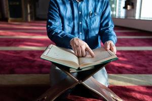 moslim Mens bidden Allah alleen binnen de moskee en lezing Islamitisch hulst boek foto