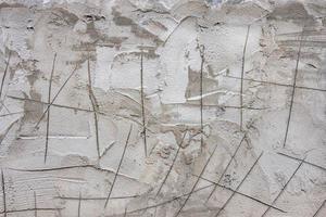 de getextureerde achtergrond van de cement muur, gepleisterd met een rustiek eenvoud met krassen merken. foto