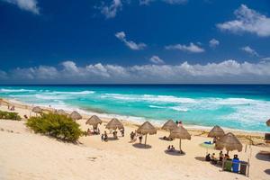 paraplu's op een zandstrand met azuurblauw water op een zonnige dag in de buurt van cancun, mexico foto
