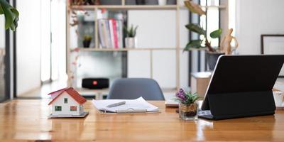 huis model- met laptop Aan tafel van echt landgoed middel in kantoor foto