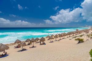 paraplu's op een zandstrand met azuurblauw water op een zonnige dag in de buurt van cancun, mexico foto