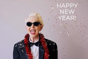 mooie stijlvolle volwassen senior vrouw in zonnebril en smoking Nieuwjaar vieren. plezier, feest, stijl, feestconcept foto