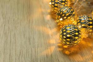 kerst gouden lichten bal decor op houten tafel. foto