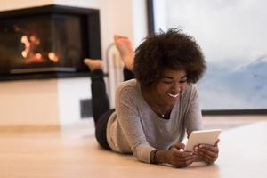 zwarte vrouwen die tabletcomputer op de vloer gebruiken foto