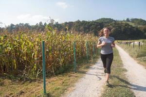 vrouw joggen langs een landweg foto