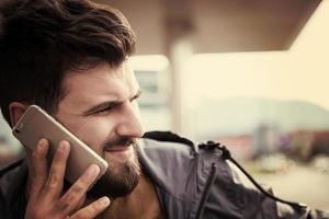 knap jong gewoontjes bedrijf Mens met baard gebruik makend van cel telefoon foto