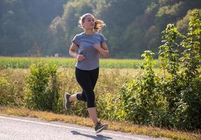 vrouw joggen langs een landweg foto