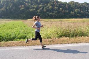 vrouw joggen langs een landweg foto