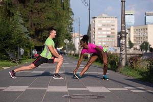 jogging paar opwarming omhoog en uitrekken in de stad foto