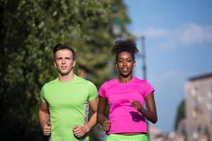 jong glimlachen multi-etnisch paar jogging in de stad foto