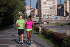 jong glimlachen multi-etnisch paar jogging in de stad foto