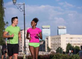 jong glimlachen multi-etnisch paar jogging in de stad foto