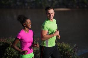 jong glimlachen multi-etnisch paar jogging in de stad foto