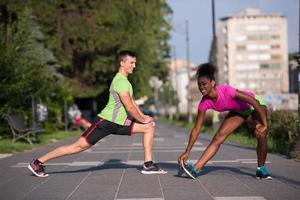 jogging paar opwarming omhoog en uitrekken in de stad foto