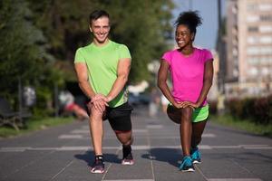 jogging paar opwarming omhoog en uitrekken in de stad foto