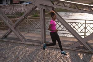 Afrikaanse Amerikaans vrouw rennen aan de overkant de brug foto