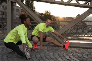 jogging paar opwarming omhoog en uitrekken in de stad foto