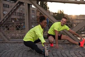 jogging paar opwarming omhoog en uitrekken in de stad foto