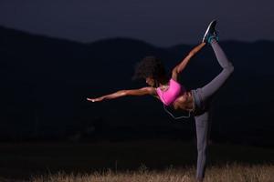 zwart vrouw aan het doen yoga in de natuur foto