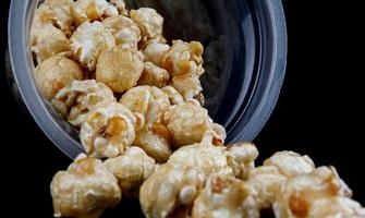 popcorn in karamel morsen uit van een plastic glas. foto