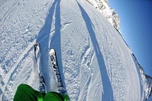 skiën op verse sneeuw in het winterseizoen op een mooie zonnige dag foto