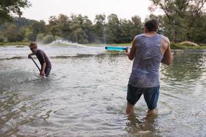 jong mannen hebben pret met water geweren foto