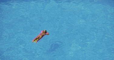 vrouw ontspannen bij zwembad foto