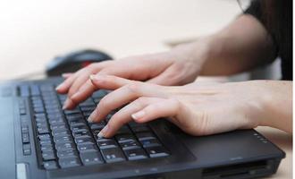vrouw handen typen op laptop toetsenbord foto