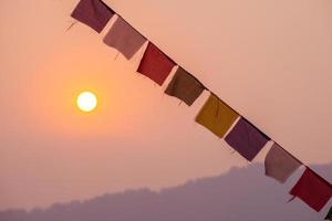 de Tibetaans gebed vlaggen en zonsopkomst of zonsondergang in Nepal. traditioneel, gebed vlaggen zijn gebruikt naar promoten vrede, medeleven, kracht, en wijsheid. foto