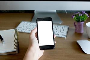 vrouw handen Holding leeg scherm van smartphone Aan hout bureau werk foto